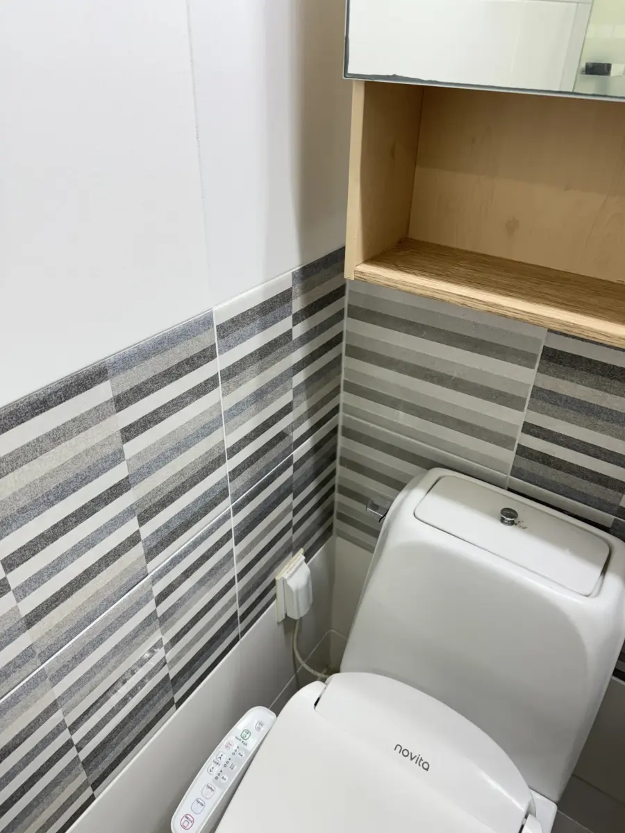 같은 줄무늬 벽타일 구간에 휴지걸이가 고정된 작업 후 실제 현장